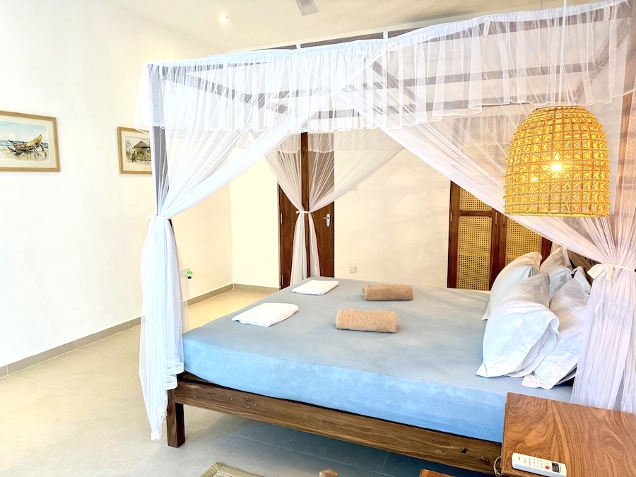 Upper-floor room with floor-to-ceiling windows and a leafy view